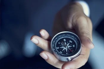 A pocket compass in a hand.